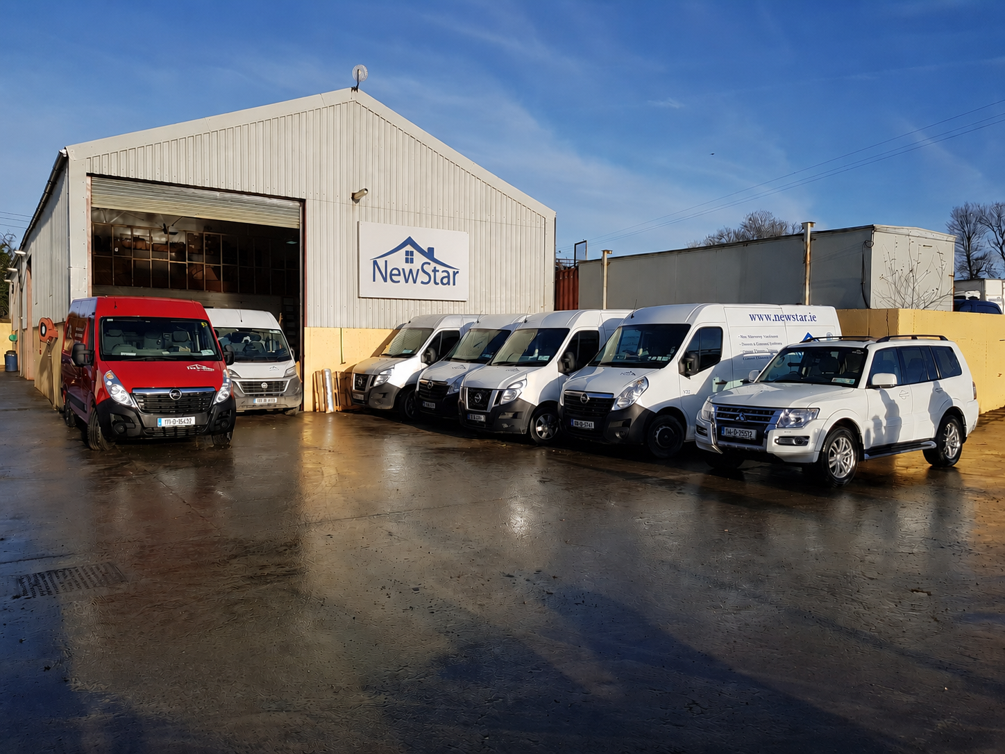 NewStar warehouse with branded sign and fleet of installation vans